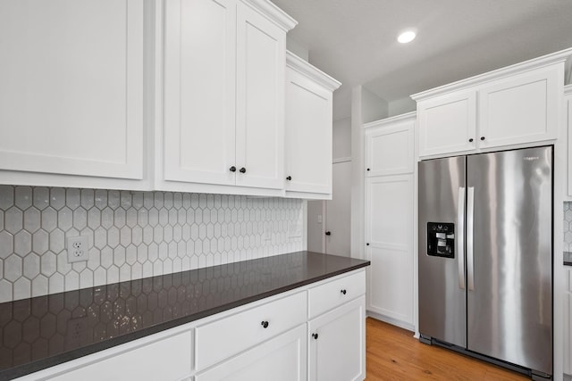 14221 Aspen Ave, Rosemount, MN 55068 - kitchen featuring stainless steel fridge, dark countertops, white cabinetry, decorative backsplash, and light wood finished floors