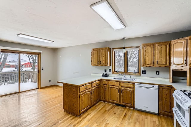8210 208th St W, Lakeville, MN 55044 - kitchen featuring white appliances, a peninsula, brown cabinets, light countertops, and light wood-type flooring