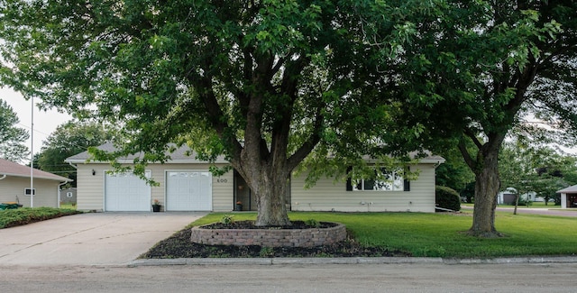 600 Venn St, Sherburn, MN 56171 - view of property hidden behind natural elements with concrete driveway, a front yard, and an attached garage