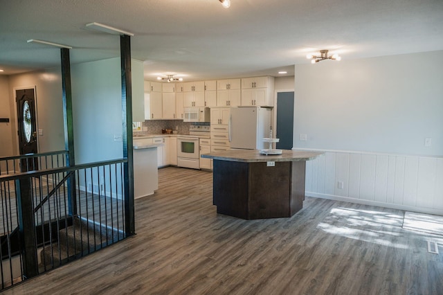 600 Venn St, Sherburn, MN 56171 - kitchen with white appliances, dark wood-style flooring, white cabinetry, a kitchen island, and a wainscoted wall