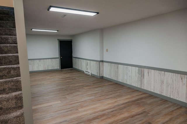 600 Venn St, Sherburn, MN 56171 - empty room with wood finished floors, stairs, wainscoting, and baseboard heating