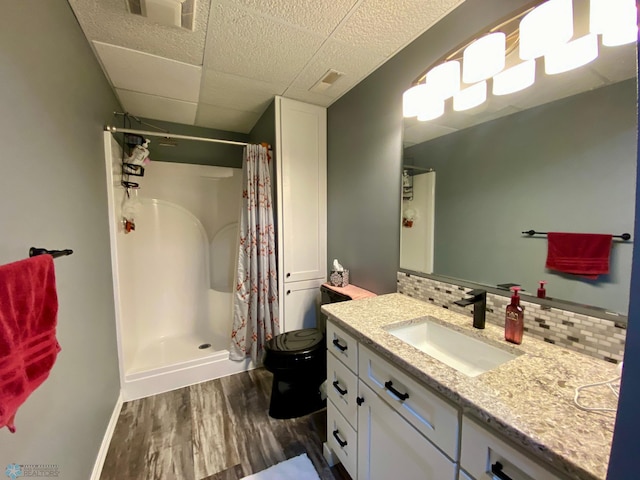 1506 Woodridge Ln, West Fargo, ND 58078 - full bathroom with wood finished floors, tasteful backsplash, vanity, a stall shower, and a paneled ceiling