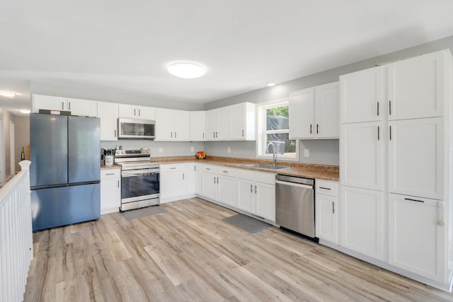 605 Central Ave SW, Cambridge, MN 55008 - kitchen featuring stainless steel appliances, light wood-type flooring, white cabinetry, and light countertops