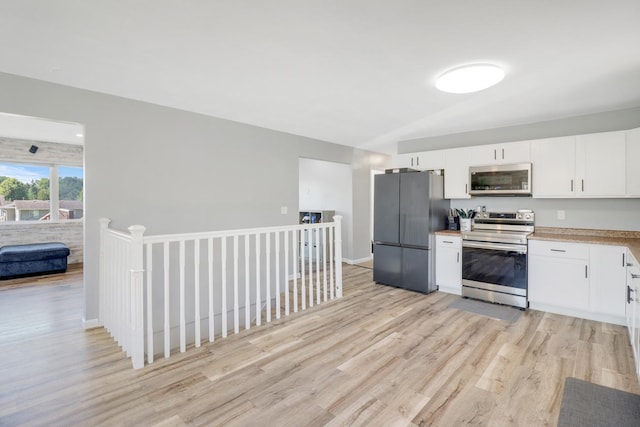 605 Central Ave SW, Cambridge, MN 55008 - kitchen featuring appliances with stainless steel finishes, light wood finished floors, white cabinets, and light countertops