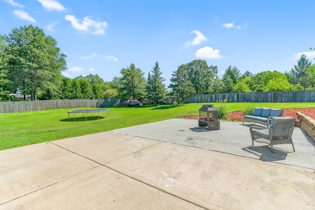 605 Central Ave SW, Cambridge, MN 55008 - fenced backyard featuring a patio, a trampoline, and an outdoor hangout area