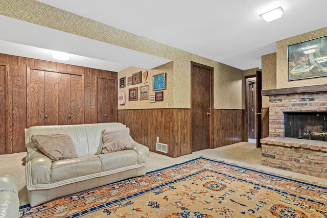6670 Maple Dr, Rockford, MN 55373 - carpeted living area featuring wooden walls, wainscoting, a brick fireplace, and a textured ceiling