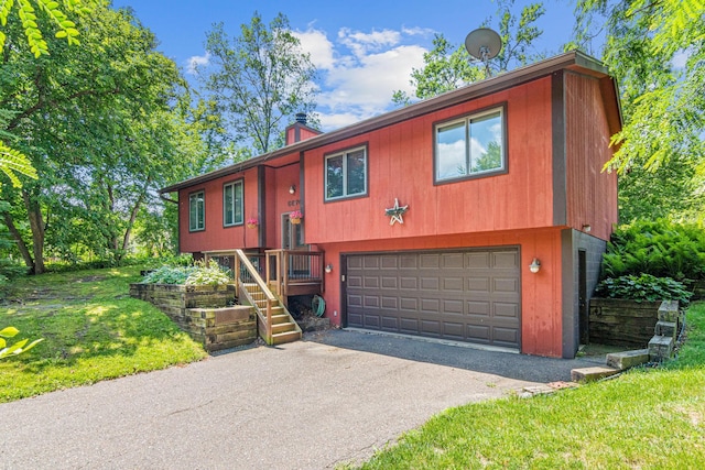 6670 Maple Dr, Rockford, MN 55373 - bi-level home with a garage, a chimney, stairs, driveway, and a front yard