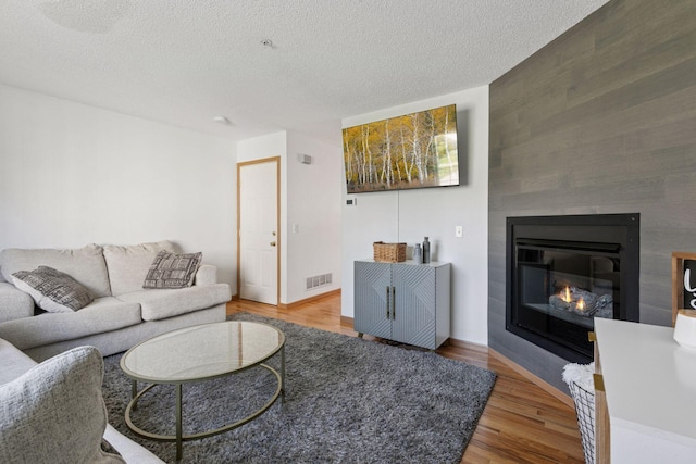 13066 Crimson Clover Ln, Eden Prairie, MN 55347 - living room with wood finished floors, a fireplace, a textured ceiling, and an accent wall