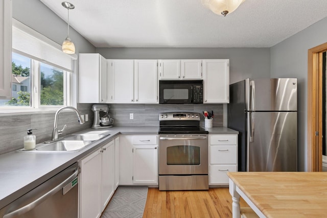 13066 Crimson Clover Ln, Eden Prairie, MN 55347 - kitchen with appliances with stainless steel finishes, white cabinetry, tasteful backsplash, light countertops, and light wood-type flooring