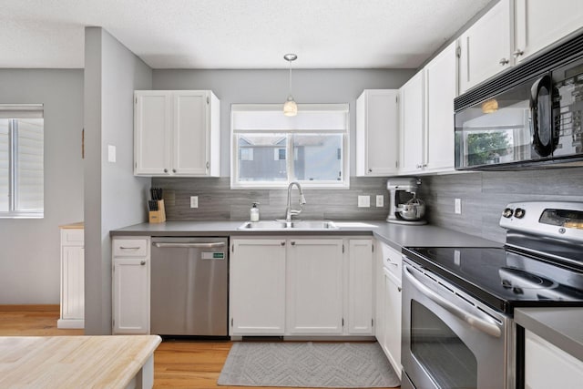 13066 Crimson Clover Ln, Eden Prairie, MN 55347 - kitchen featuring appliances with stainless steel finishes, backsplash, light wood-type flooring, white cabinets, and a textured ceiling