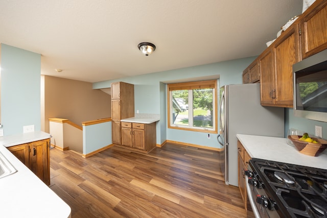 10815 Matthew Dr, Chisago City, MN 55013 - kitchen with brown cabinets, light countertops, stainless steel microwave, wood finished floors, and gas stove