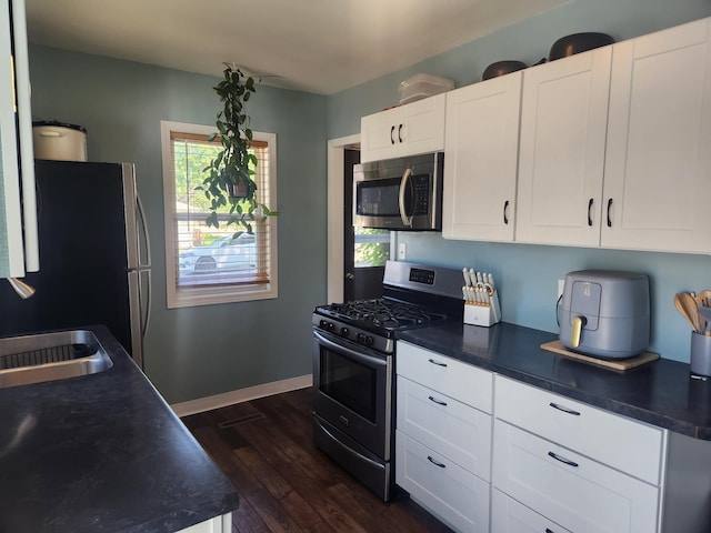 1302 Clark St, Albert Lea, MN 56007 - kitchen with stainless steel appliances, healthy amount of natural light, dark wood-style flooring, and dark countertops