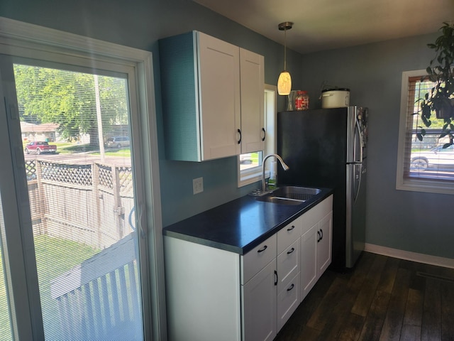 1302 Clark St, Albert Lea, MN 56007 - kitchen with dark countertops, freestanding refrigerator, dark wood finished floors, and plenty of natural light