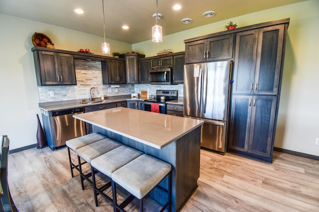 412 Hampton Dr W, Moorhead, MN 56560 - kitchen with appliances with stainless steel finishes, dark brown cabinetry, light wood-style floors, decorative backsplash, and recessed lighting