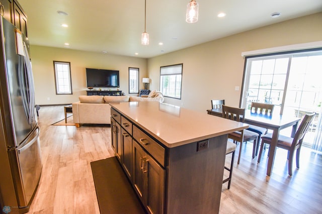 412 Hampton Dr W, Moorhead, MN 56560 - kitchen with freestanding refrigerator, a kitchen breakfast bar, light wood-type flooring, plenty of natural light, and recessed lighting