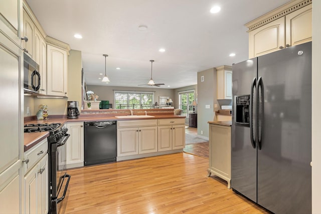 56668 145th Ave, West Concord, MN 55985 - kitchen with black appliances, cream cabinetry, a peninsula, light wood finished floors, and recessed lighting