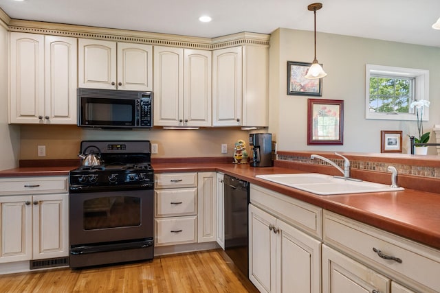 56668 145th Ave, West Concord, MN 55985 - kitchen featuring black appliances, cream cabinetry, decorative light fixtures, recessed lighting, and light wood-style flooring