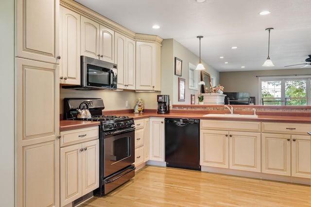 56668 145th Ave, West Concord, MN 55985 - kitchen with cream cabinetry, black appliances, hanging light fixtures, a ceiling fan, and light wood-style flooring