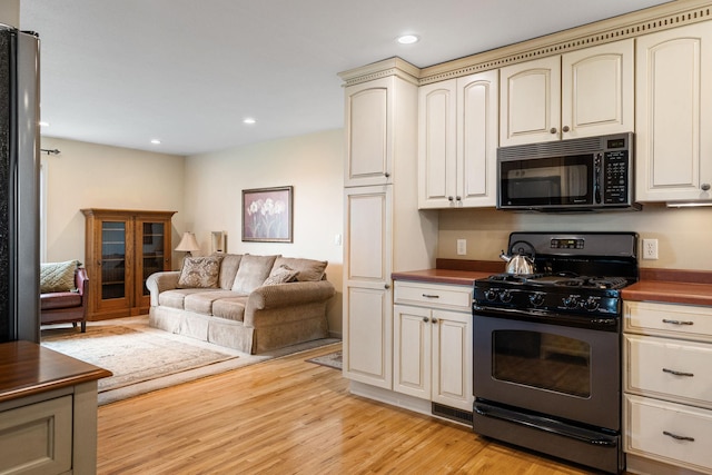 56668 145th Ave, West Concord, MN 55985 - kitchen featuring black microwave, range with gas cooktop, cream cabinetry, open floor plan, and recessed lighting