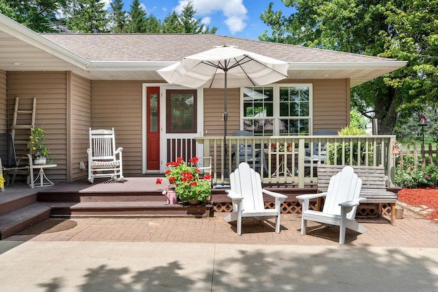 56668 145th Ave, West Concord, MN 55985 - doorway to property with a shingled roof, a deck, and a patio area