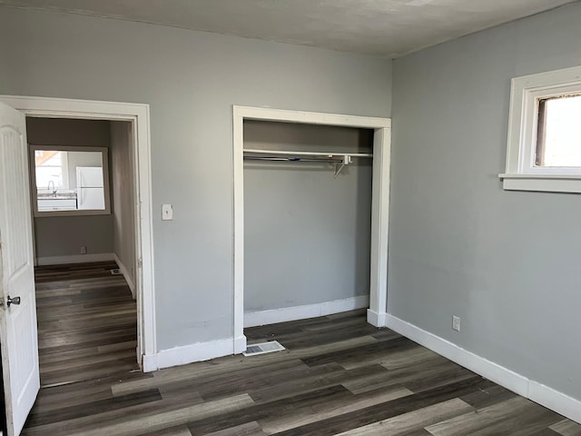 1026 Fremont Ave, Saint Paul, MN 55106 - unfurnished bedroom with freestanding refrigerator, dark wood-style flooring, and a closet