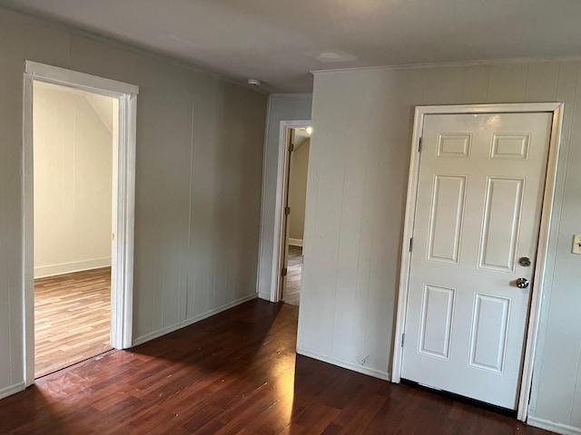 1026 Fremont Ave, Saint Paul, MN 55106 - unfurnished bedroom with dark wood-style flooring, crown molding, and a decorative wall
