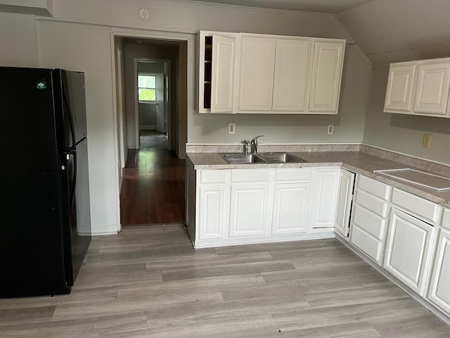 1026 Fremont Ave, Saint Paul, MN 55106 - kitchen with freestanding refrigerator, white cabinets, light wood finished floors, vaulted ceiling, and light countertops