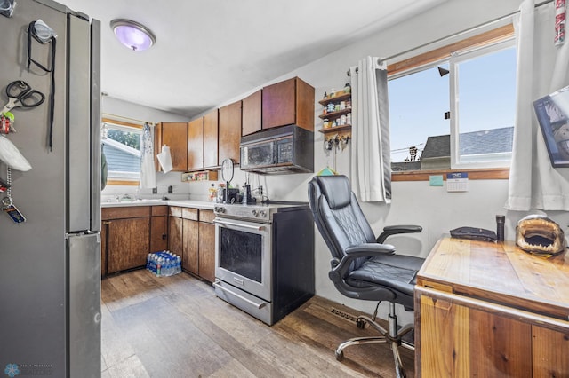 1330 16 1/2 St S, Fargo, ND 58103 - kitchen featuring appliances with stainless steel finishes, light wood-type flooring, brown cabinets, and light countertops