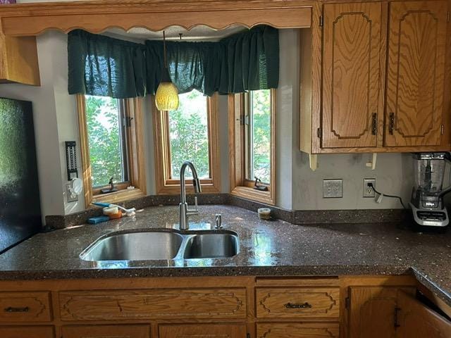 3324 131st Ln NW, Coon Rapids, MN 55448 - kitchen featuring healthy amount of natural light, brown cabinets, and dark stone countertops