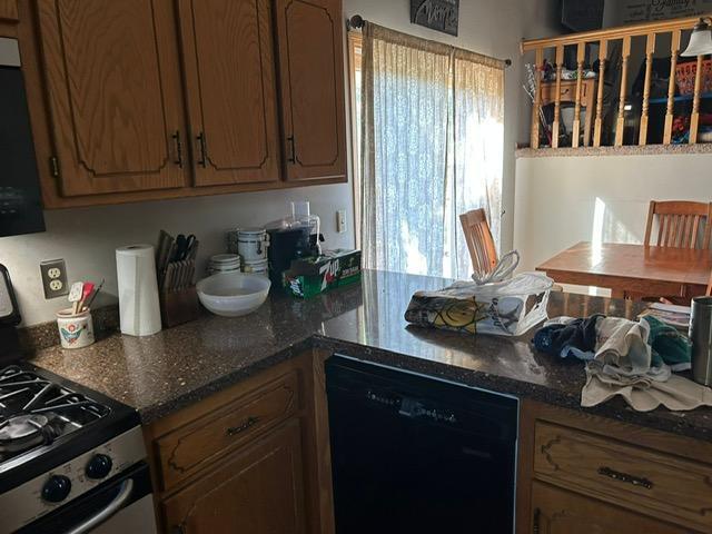 3324 131st Ln NW, Coon Rapids, MN 55448 - kitchen with dishwasher, stainless steel gas stove, dark stone counters, a peninsula, and brown cabinets