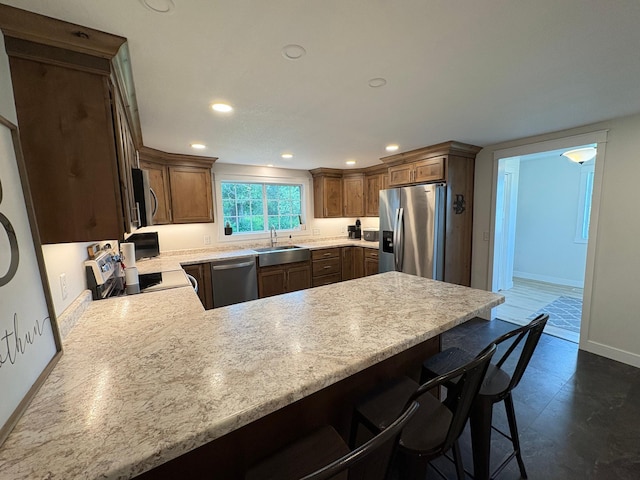 2812 150th St, Maxwell Twp, MN 56232 - kitchen with appliances with stainless steel finishes, light countertops, a peninsula, recessed lighting, and a breakfast bar area