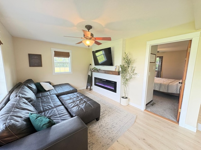 2812 150th St, Maxwell Twp, MN 56232 - living room featuring wood finished floors, ceiling fan, and a glass covered fireplace