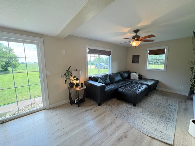 2812 150th St, Maxwell Twp, MN 56232 - living room with light wood finished floors, a ceiling fan, and beam ceiling