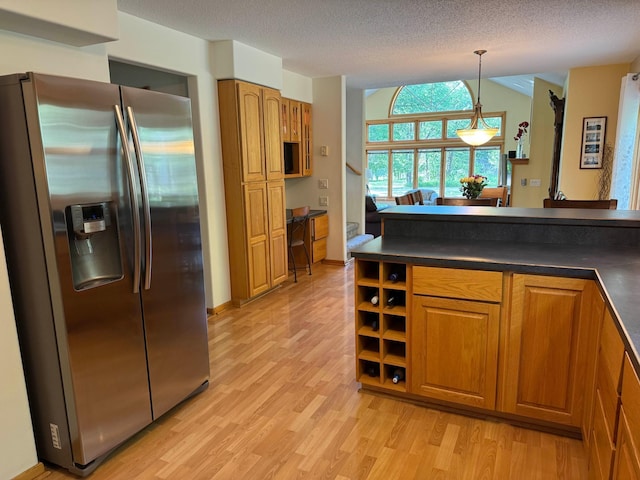 14158 185th Ave NE, Smiley Twp, MN 56701 - kitchen with stainless steel refrigerator with ice dispenser, dark countertops, brown cabinets, lofted ceiling, and a textured ceiling