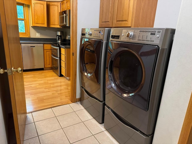 14158 185th Ave NE, Smiley Twp, MN 56701 - laundry room featuring washer and clothes dryer, cabinet space, and light tile patterned floors