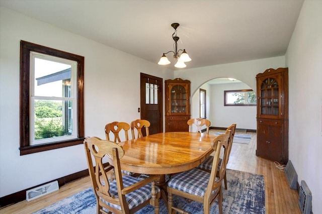 N7420 110th St, Spring Lake Twp, WI 54767 - dining area featuring arched walkways, light wood-style floors, and a chandelier