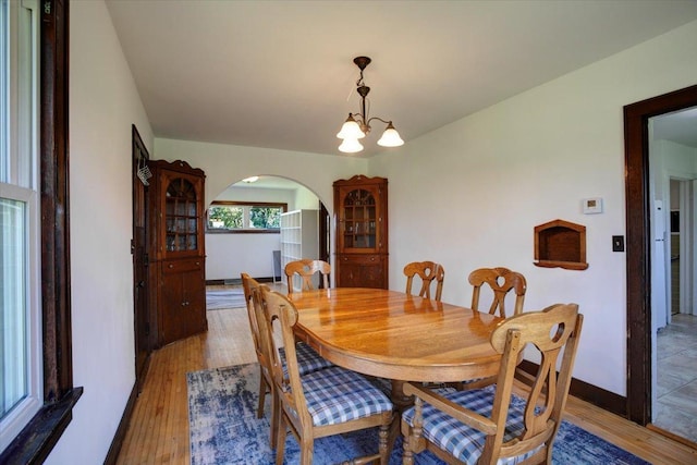 N7420 110th St, Spring Lake Twp, WI 54767 - dining space featuring arched walkways, light wood-style flooring, and a chandelier