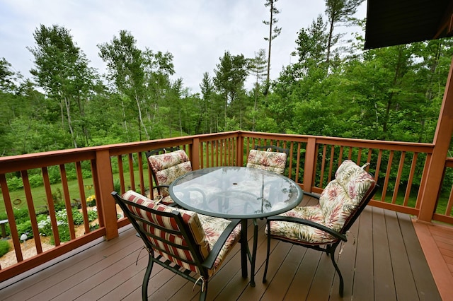 N5020 Red Pine Trl, Evergreen Twp, WI 54801 - wooden terrace with outdoor dining space and a view of trees