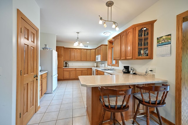 N5020 Red Pine Trl, Evergreen Twp, WI 54801 - kitchen with white appliances, a peninsula, light countertops, glass insert cabinets, and a breakfast bar
