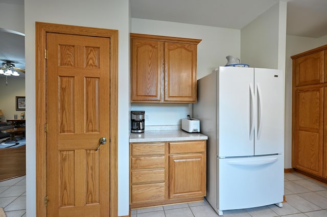 N5020 Red Pine Trl, Evergreen Twp, WI 54801 - kitchen featuring freestanding refrigerator, light tile patterned flooring, light countertops, ceiling fan, and brown cabinets