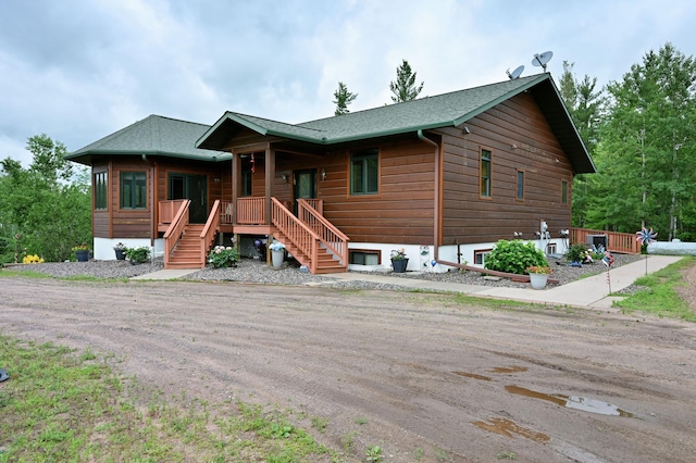 N5020 Red Pine Trl, Evergreen Twp, WI 54801 - chalet / cabin with covered porch, a shingled roof, and stairway