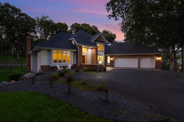 11280 Bluestem Ln, Eden Prairie, MN 55347 - view of front of house featuring asphalt driveway, brick siding, an attached garage, a chimney, and roof with shingles