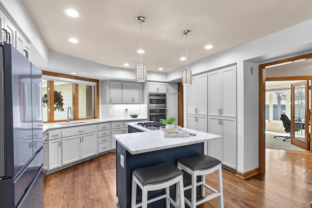 11280 Bluestem Ln, Eden Prairie, MN 55347 - kitchen with appliances with stainless steel finishes, a center island, light stone countertops, recessed lighting, and dark wood-style flooring