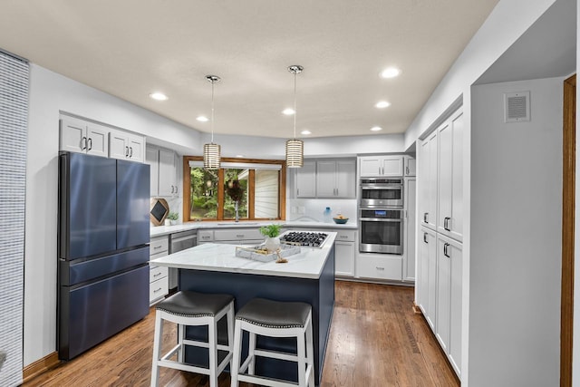11280 Bluestem Ln, Eden Prairie, MN 55347 - kitchen with stainless steel appliances, a kitchen island, dark wood-type flooring, a kitchen breakfast bar, and recessed lighting