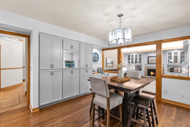 11280 Bluestem Ln, Eden Prairie, MN 55347 - dining room featuring a chandelier, dark wood-style floors, and a fireplace