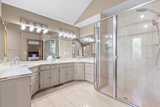11280 Bluestem Ln, Eden Prairie, MN 55347 - bathroom with double vanity, tile patterned floors, vaulted ceiling, a stall shower, and connected bathroom