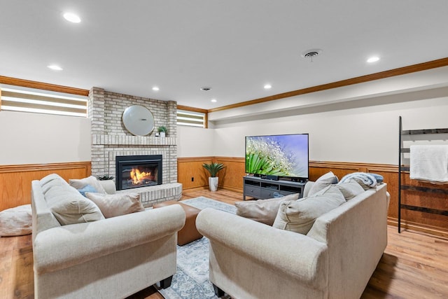 11280 Bluestem Ln, Eden Prairie, MN 55347 - living area with a wainscoted wall, crown molding, a brick fireplace, wood finished floors, and recessed lighting