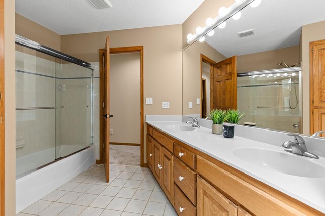 11280 Bluestem Ln, Eden Prairie, MN 55347 - full bathroom with tile patterned flooring, double vanity, and bath / shower combo with glass door