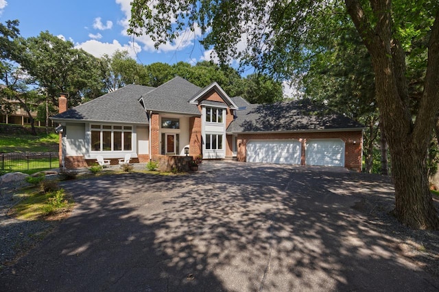 11280 Bluestem Ln, Eden Prairie, MN 55347 - view of front of property with asphalt driveway, brick siding, an attached garage, and a chimney