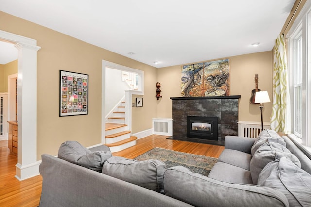 901 42nd St, Minneapolis, MN 55409 - living room featuring light wood finished floors, stairway, ornate columns, and a tile fireplace